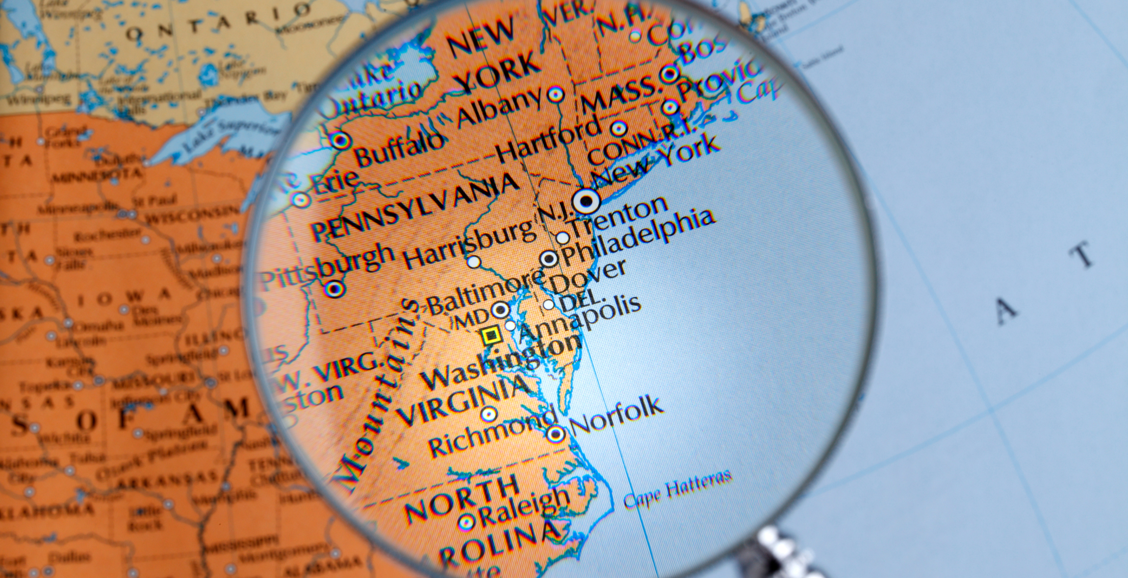 a magnifying glass that is focusing and enlarging the East Coast of the United States