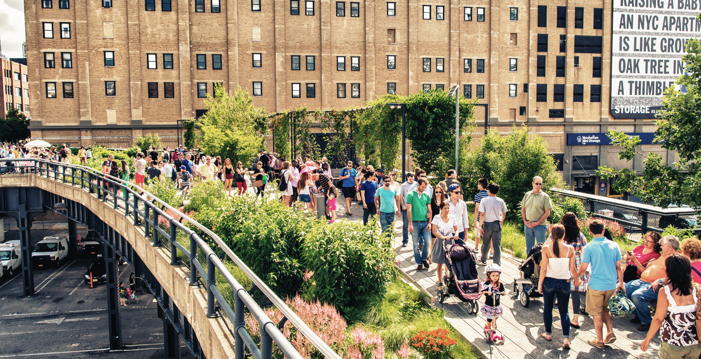 people walk across the highline in NYC passing one another.